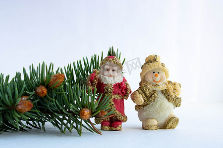 圣诞老人、雪人和云杉树枝，白色背景上有小年轻的锥体。新年和圣诞节的概念