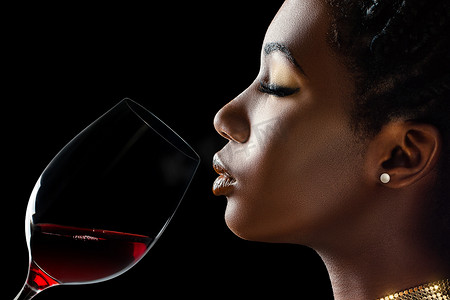 非洲女人嗅着红酒的香气。