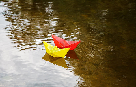 漂浮在溪流上的两艘五颜六色的纸船