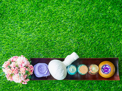 紫色渐变磨砂摄影照片_绿色草坪上健康皮肤的水疗磨砂配饰。
