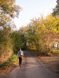 后面的人带着 tr 走在秋天的乡村小路上