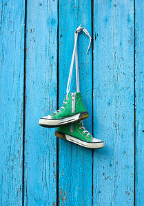 绿色经典摄影照片_几双旧纺织绿色经典运动鞋挂在绳子上