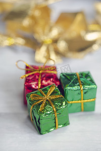 礼盒一堆摄影照片_一堆彩色闪亮礼盒，白色木质背景上有复制空间，现代复古圣诞设计，色彩缤纷的礼物，节日概念