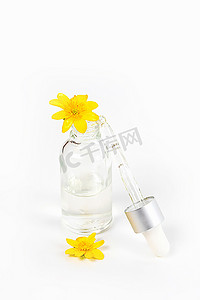 黄色春花中白色背景上装有吸管血清的瓶子