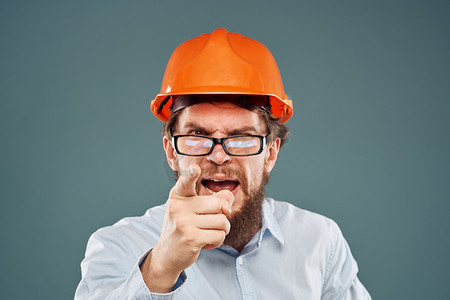 戴橙色头盔衬衫眼镜后手势裁剪视图工业建筑