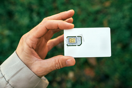 超高频模块摄影照片_拿着手机SIM卡的男性手