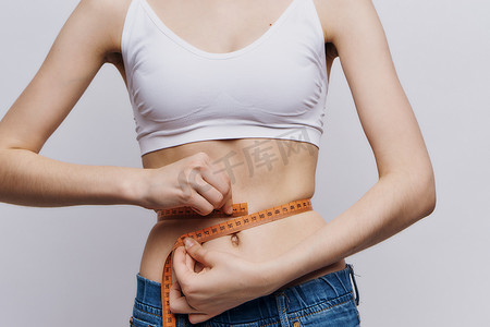 瘦出魔鬼身材摄影照片_女人测量腰部苗条身材饮食生活方式