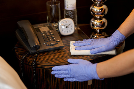 酒店女服务员摄影照片_女佣对酒店房间表面进行消毒