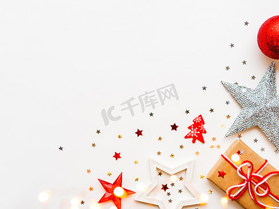 白色闪亮星星摄影照片_圣诞和新年装饰背景-闪亮的星星、球、雪花、心形、五彩纸屑和灯泡。
