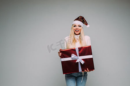 微笑的漂亮女士拿着带礼品丝带弓的红色礼盒