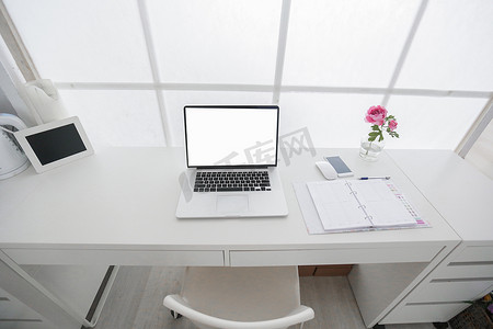 现代室内工作场所，配备白色笔记本电脑