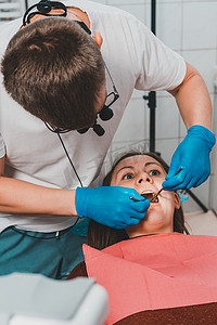 双合诊检查摄影照片_牙医在治疗牙齿的问题区域之前会检查口腔。