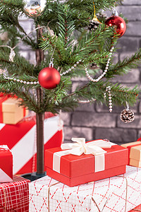 装饰圣诞树，家里包裹着美丽的红白礼物，黑砖墙，节日设计理念，特写。