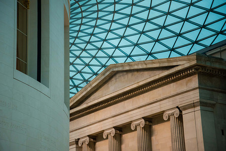 岭南屋顶摄影照片_大英博物馆大庭院的未来主义玻璃天花板屋顶与柱子和其他建筑形状并列。