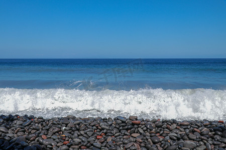 大海浪拍岸摄影照片_海上三四点小风暴，海浪拍岸有大卵石。