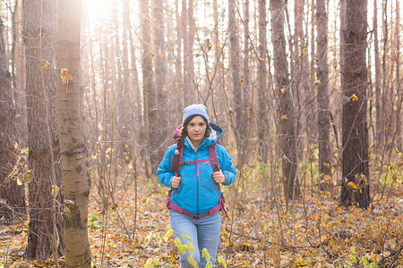 人与树摄影照片_人与自然概念 — 背着背包在森林里徒步旅行的女性肖像