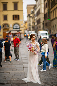 意大利佛罗伦萨，身穿婚纱、手里拿着威尼斯面具的新娘