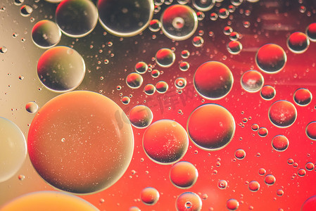 干冰泡泡摄影照片_用油、水和肥皂制成的红色抽象背景图片