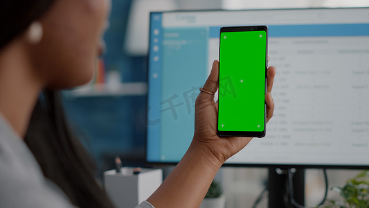 非洲妇女手持带有独立显示屏的模拟绿屏色度键手机的特写