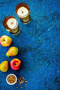 中同摄影照片_蓝色背景中带苹果和梨的果汁饮料，来自上方的复制空间