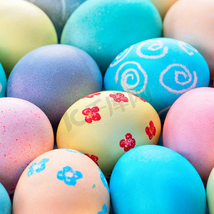 彩色复活节彩蛋被彩色水染色，淡蓝色背景上有美丽的图案，假日活动的设计理念，顶视图，全框。