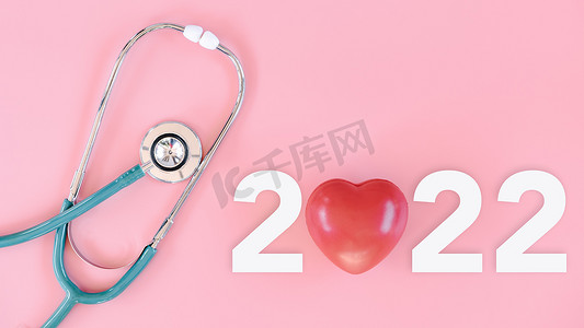 2022 年概念的体检和健康保险，带文本新年 2022 年的听诊器，隔离粉红色背景。 