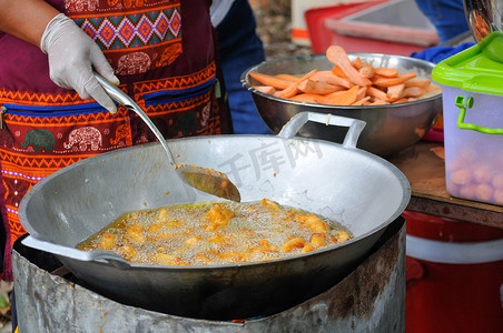 莱热摄影照片_将红薯放入煎锅中，用热棕榈油煎炸