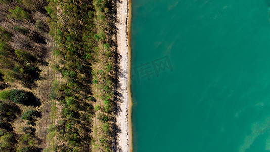 架空摄影照片_空中无人机俯视森林与蓝湖边缘海滩