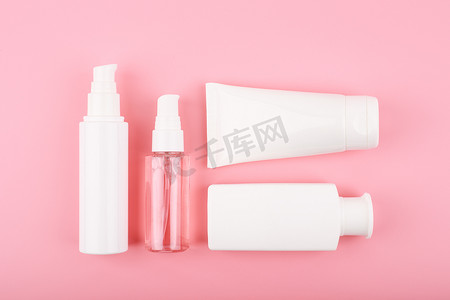 口腔护理液摄影照片_平躺，配有一套美容产品、泡沫、乳液、奶油、面膜和磨砂膏，用于粉红色背景下的日常皮肤护理