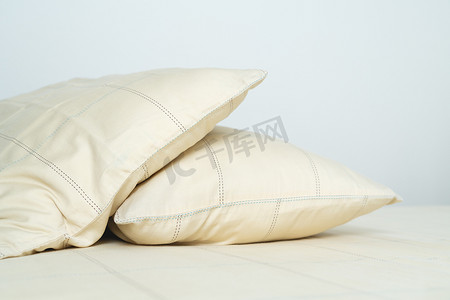 舒适柔软舒适摄影照片_床上有几个舒适柔软的黄色枕头