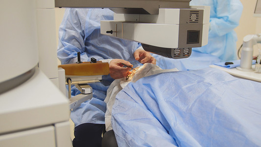 麻醉医生摄影照片_眼科手术无麻醉-激光视力矫正时患者躺在手术台上