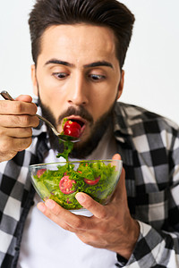 穿格子衬衫的男人吃沙拉健康食品