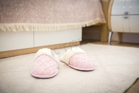 现代风格的卧室，地板上配有粉色舒适的软拖鞋