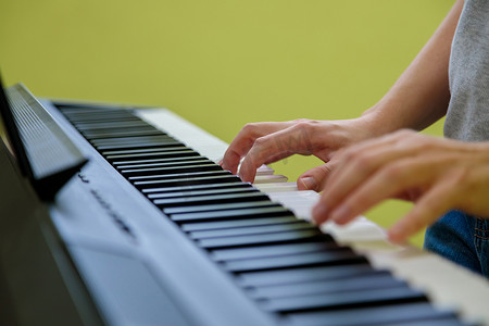 弹电子钢琴的女孩的手。