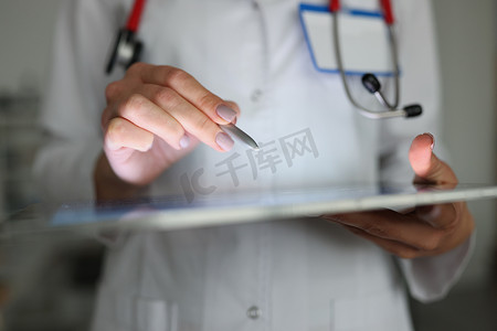 医生使用平板电脑纠正患者病史，现代设备帮助临床工作
