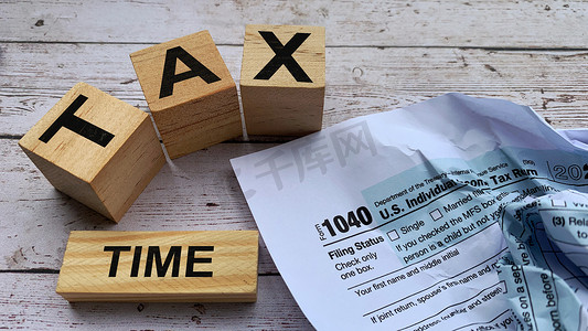 纳税时间标记在带有税表背景的木块上。
