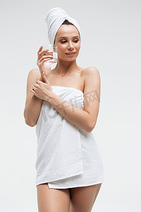 头上戴着白毛巾、喝着纯净水、看着别处的自信放松的女人