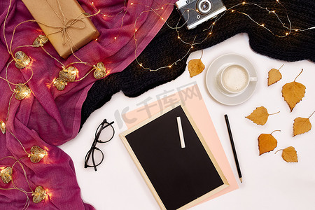目装饰摄影照片_一杯咖啡、一块黑色小木板和一支写有新年目标的白色粉笔。