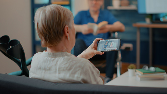 智能聊天摄影照片_老妇人使用智能手机与医院的家人进行视频通话