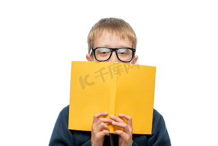 一个戴眼镜、拿着教科书的男生的特写肖像