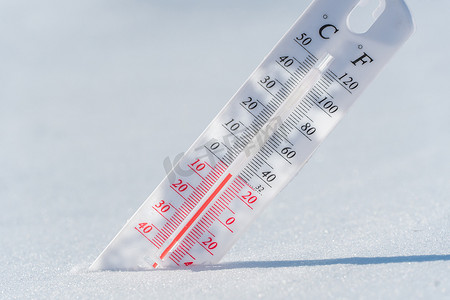 温度计位于雪上，在蓝天的寒冷天气中显示负温度。空气和环境温度低的气象条件。气候变化和全球变暖