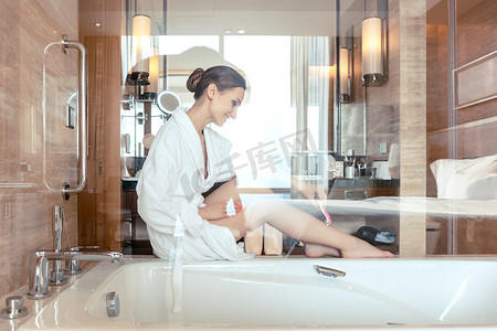 松毛汤包摄影照片_女人在酒店浴室里剃腿毛
