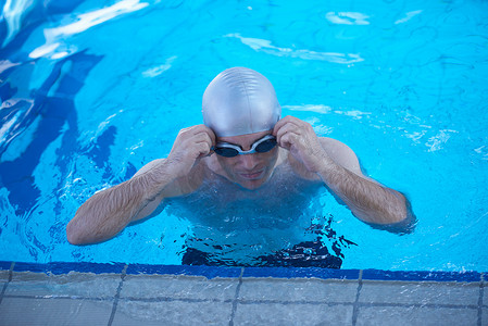 室内游泳池摄影照片_游泳者在室内游泳池便便上锻炼