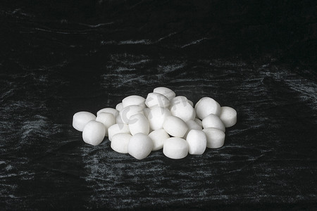 中药熏蒸疗法摄影照片_黑色天鹅绒上的白色萘球