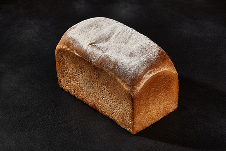 整条新鲜美味的烤白面包撒上面粉。