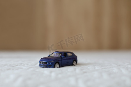 纺织材料宏观拍摄的微型蓝色塑料玩具车。