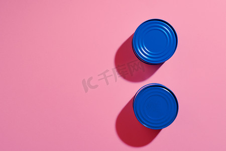 粉红色背景上蓝色彩绘锡罐的美学概念