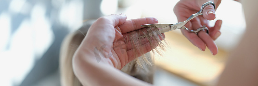 美发师用剪刀剪女人的头发，手特写