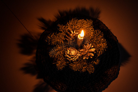 头饰装饰摄影照片_优雅的圣诞头饰，在环境灯中点燃蜡烛