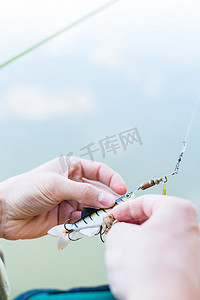 钓鱼者将诱饵固定在钓鱼竿的蹄部